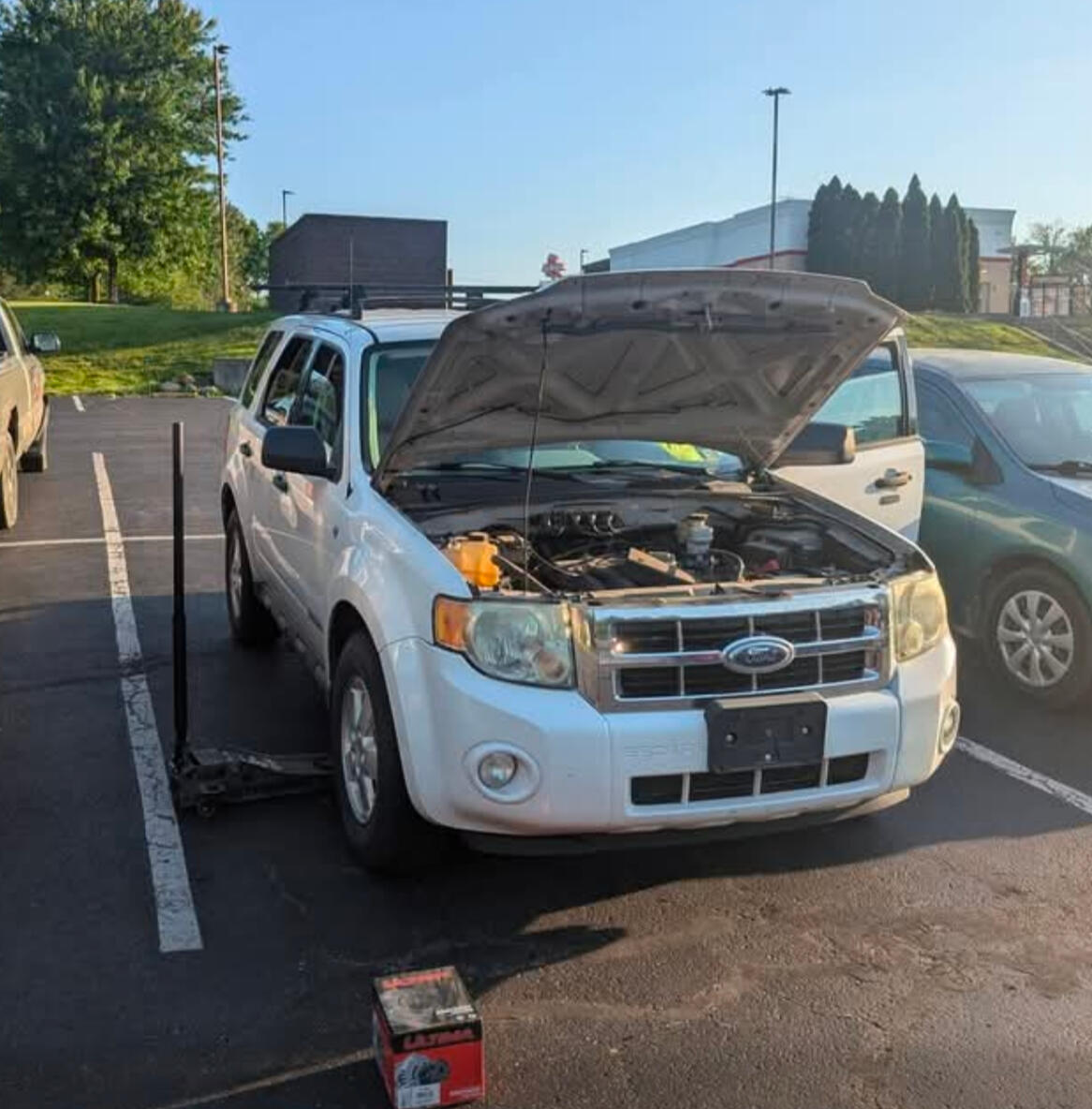 Mobile mechanic performing alternator replacement on a Ford Escape in a parking lot in Fort Worth TX